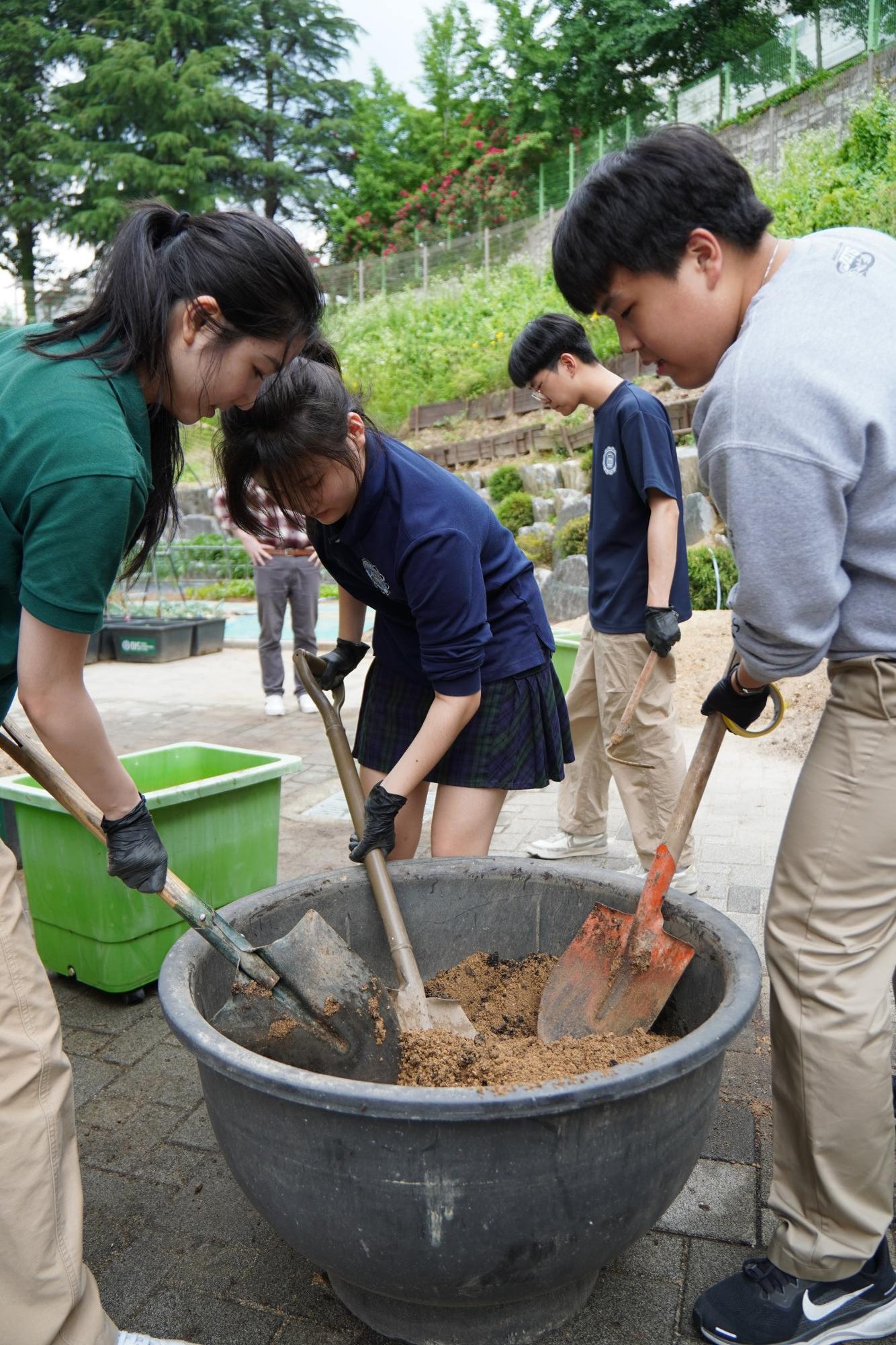 Eco-Lution members preparing compost batches in the school garden